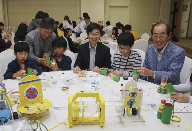 17일 서울대 글로벌공학교육센터에서 열린 ‘주니어공학기술교실’에 참가한 이학성 LS산전 부사장, 박성욱 SK하이닉스 사장, 윤종용 국가지식재산위원회 위원장(왼쪽부터)이 학생들과 함께 자가발전 손전등을 만들고 있다. - 홍진환 기자 jean@donga.com 제공